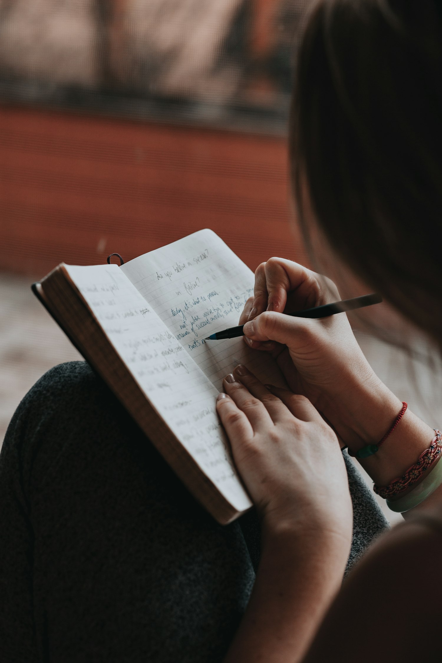 Hands writing a note in a journal, a quiet moment of reflection