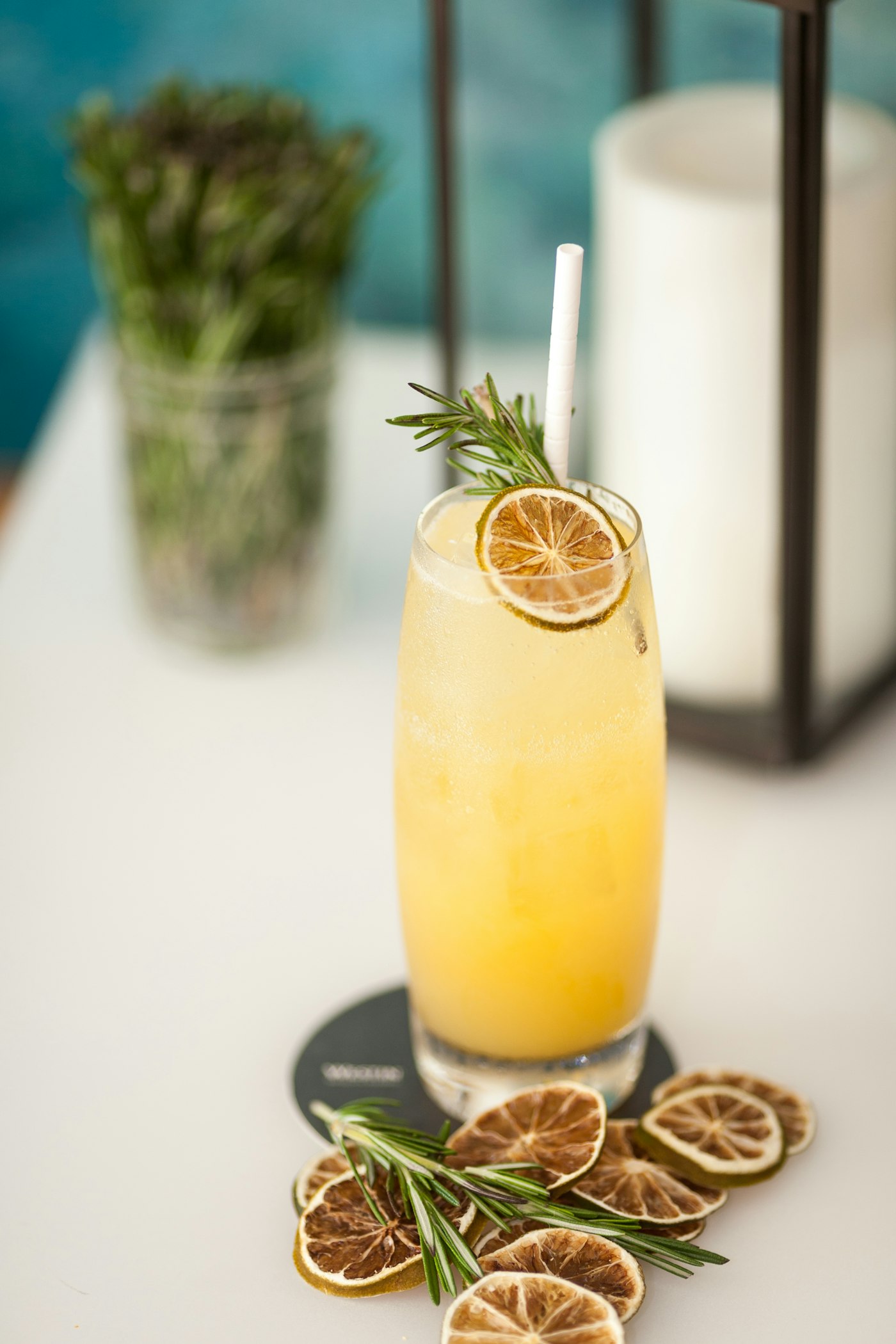 A bright citrus mocktail garnished with rosemary on a clean table